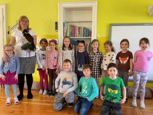 Zdjęcie przedstawia grupę dzieci, z nauczycielką, która trzyma sowę.